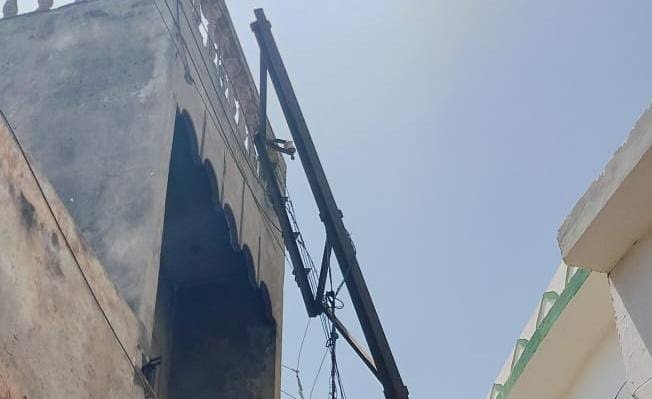 एक सप्ताह से मकान की रेलिंग पर टिका विद्युत पोल, सूचना के बाद भी विभागीय अधिकारी कुंभकर्णी नींद में